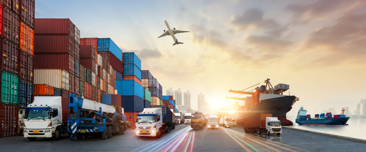 A plane flies directly over a port with trucks, a container ship and rows of containers. This is to show how logistics tech can positively change all aspects of the supply chain